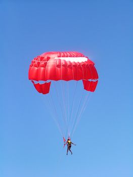 The girl flies on a parachute which is towed by a motor boat     