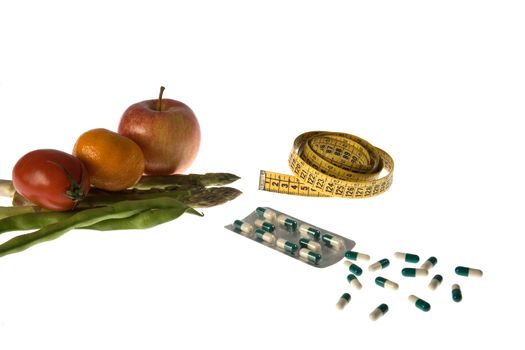 Fruits and vegetables, pills and a measure tape  representing ways to slimming.