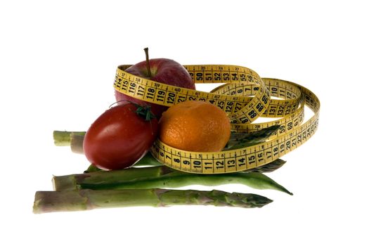 Tape measure wrapped around fruits and vegetables as a metaphor of healthy slimming diet.