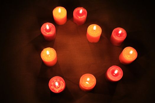 Some candles in heart-shaped composition on linen background