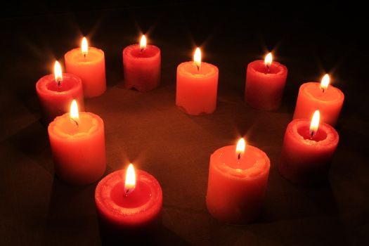 Some candles in heart-shaped composition on linen background