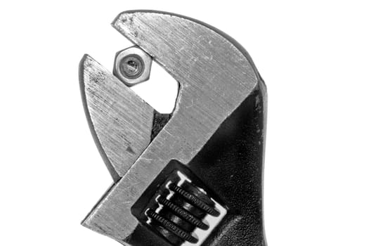 A closeup shot of an adjustable wrench with a firm grip on a nut and bolt on a white background