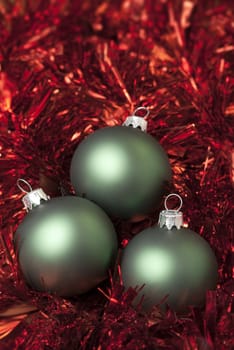 Green christmas ball on the red tinsel. aRGB.