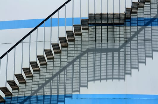 stairs climbing a white round wall with blue lines
