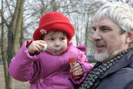 Granddaughter with grandfather released soap bubbles