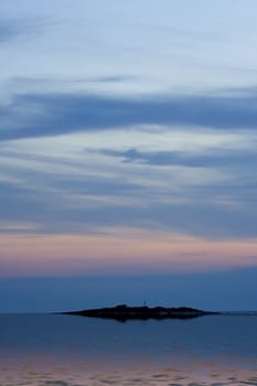 Island below sunet sky with reflection