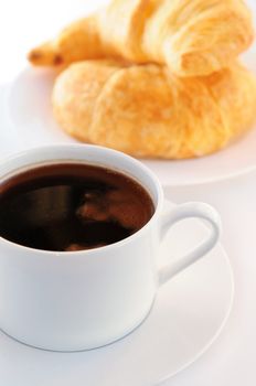 Breaksfast of black coffee and fresh croissants