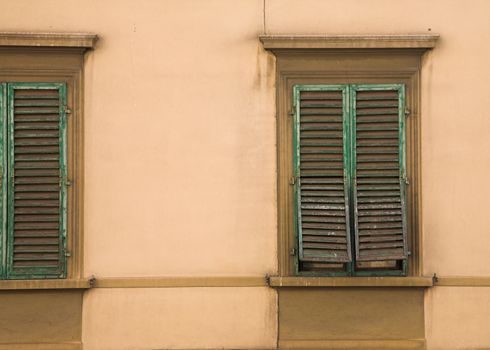 Typical windows of Tuscany in Italy, with shutters closed.