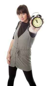 Pretty brunette girl showing alarm clock; only clock is in focus