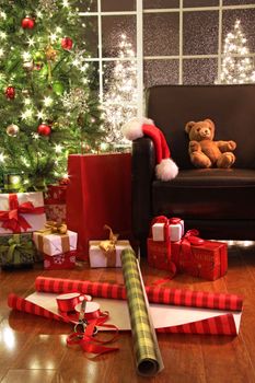 Christmas tree with gifts and teddy bear on chair