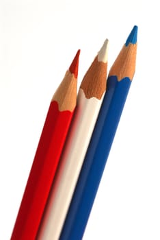 Red, blue and white pencils on white background. A close up