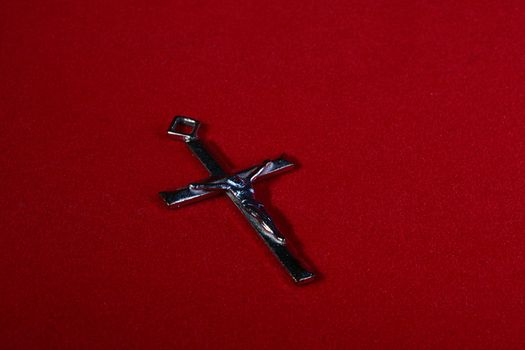 Catholic cross without a chain on a red velvet.