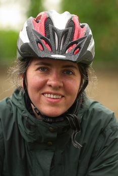 Woman out on a bike trail with her helmet on. 