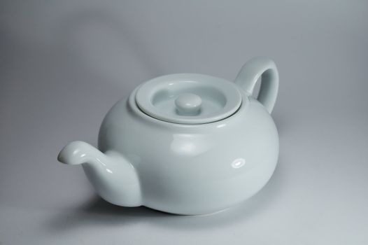 white porcelain tea-pot on a light background, studio illumination