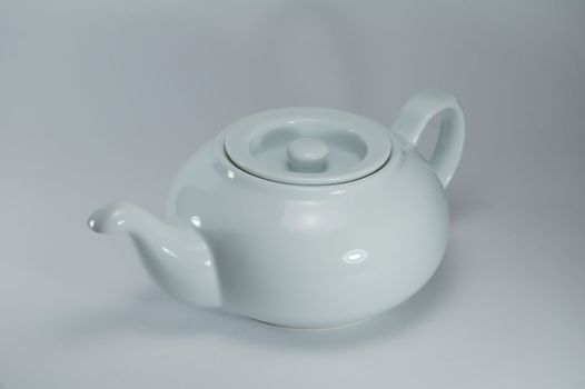 white porcelain tea-pot on a light background, studio illumination