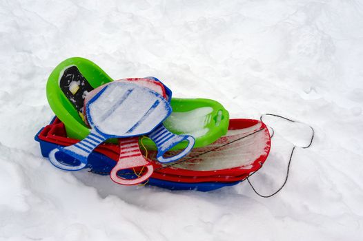 The multi-coloured children's sledge forgotten on a hill