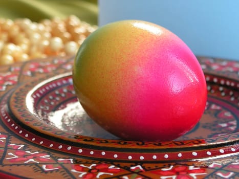 Colourful Easter egg on decorative plate macro