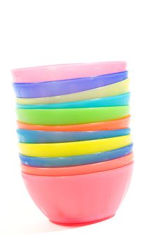 Stack of colorful plastic bowls over white background