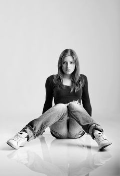 Beautiful young fashion model seated on the floor