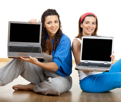 Two beautiful young women holding laptops over white background