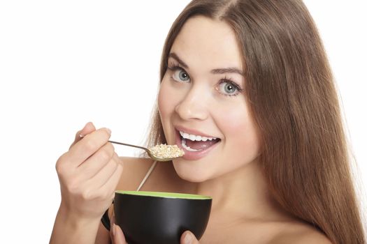 portrait of young caucasian woman eating cereals, isolated over white background.