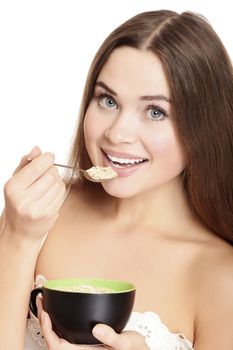 portrait of young caucasian woman eating cereals, isolated over white background