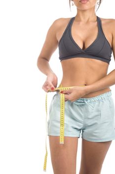 A sexy young hispanic woman wearing a gym outfit, isolated on a white background.