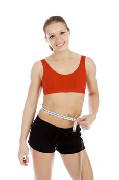 Sport woman with measuring tape posing against white background