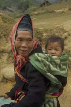 Phu La ethnic woman and her headdress characteristic. The temperature has dropped for some time. It's cold in the mountains so she put this scarf to protect his ears.