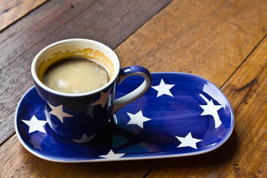 Cup of coffee and  saucer on a wooden floor