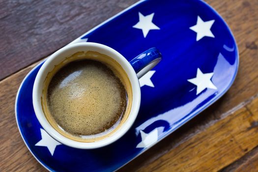 Cup of coffee and  saucer on a wooden floor