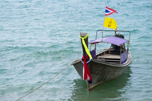 Traditional thai boat decorated with ribbons and flag