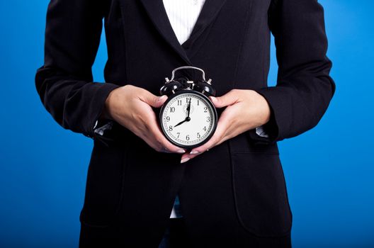 Businesswoman holding an hold clock on both hands
