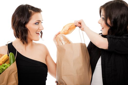 Two females with paper shopping bags full, both holding one small baguette