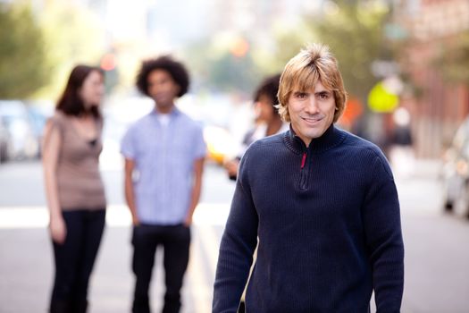 A group of people in a city setting - a caucasian male in the foreground