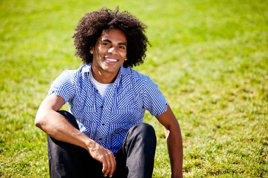 A young african american man isolated on grass with big smile