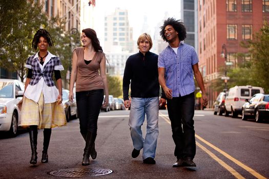 A group of young people walking down a street in a large city