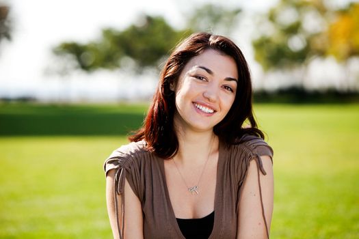 A happy young student outside in a park