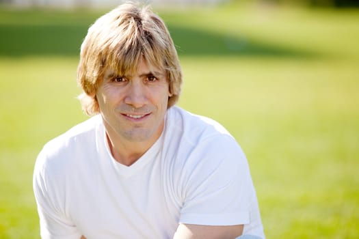 A happy confident male outside in a park