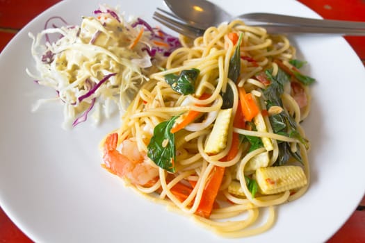 spaghetti whit shrimp and basil fried on a white dish