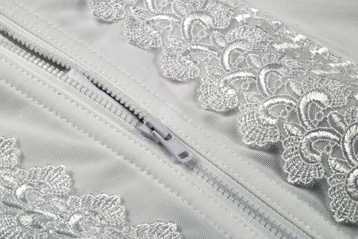 picture of a zipper in a white and laced girdle