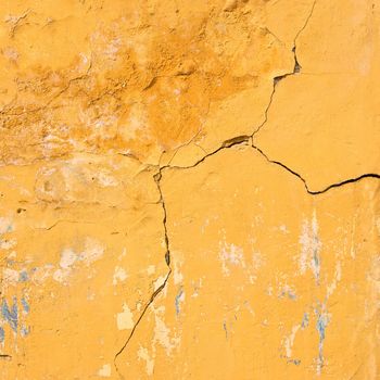 Cracks on the sienna old wall, grunge background