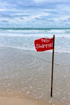 Red flag with warning text "no swimming"