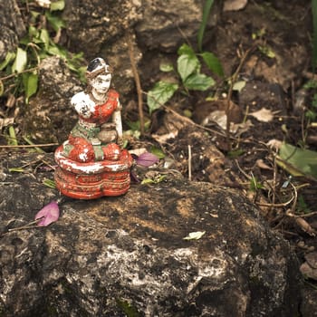 Old forgotten figurine of woman on the stone