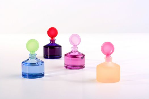 Colour small small bottles with cosmetics for care of a skin on a white background.