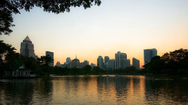 Water reflection of skyscrapers in Lumphini park, Bangkok, Thailand