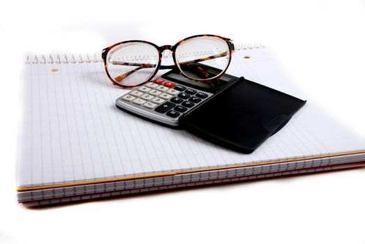 Pictures of a calculator and glasses resting on a notepad, ready to do calculations