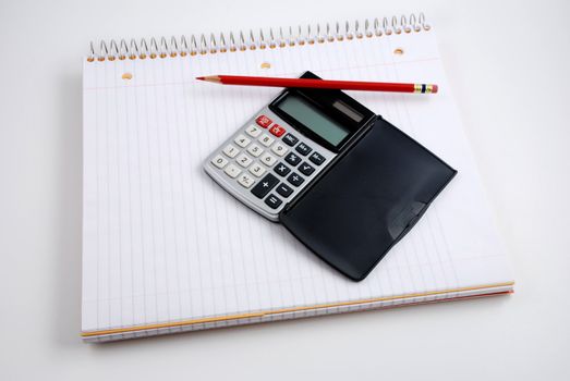 Pictures of a calculator and glasses resting on a notepad, ready to do calculations