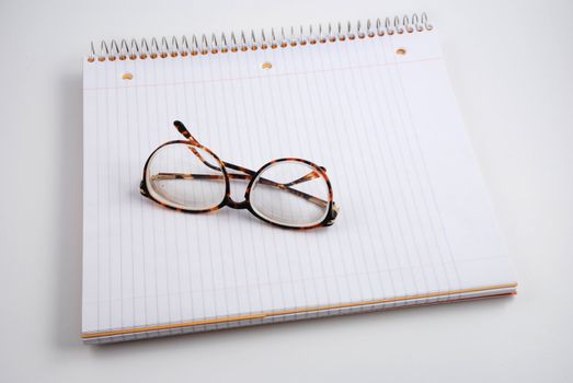 Pictures of glasses resting on a notepad, indicating the writer is taking a break from thinking