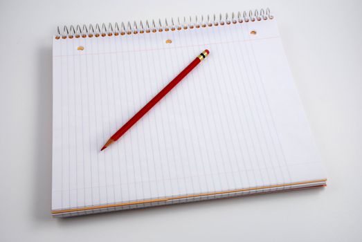 Pictures of a pencil resting on top of a notepad